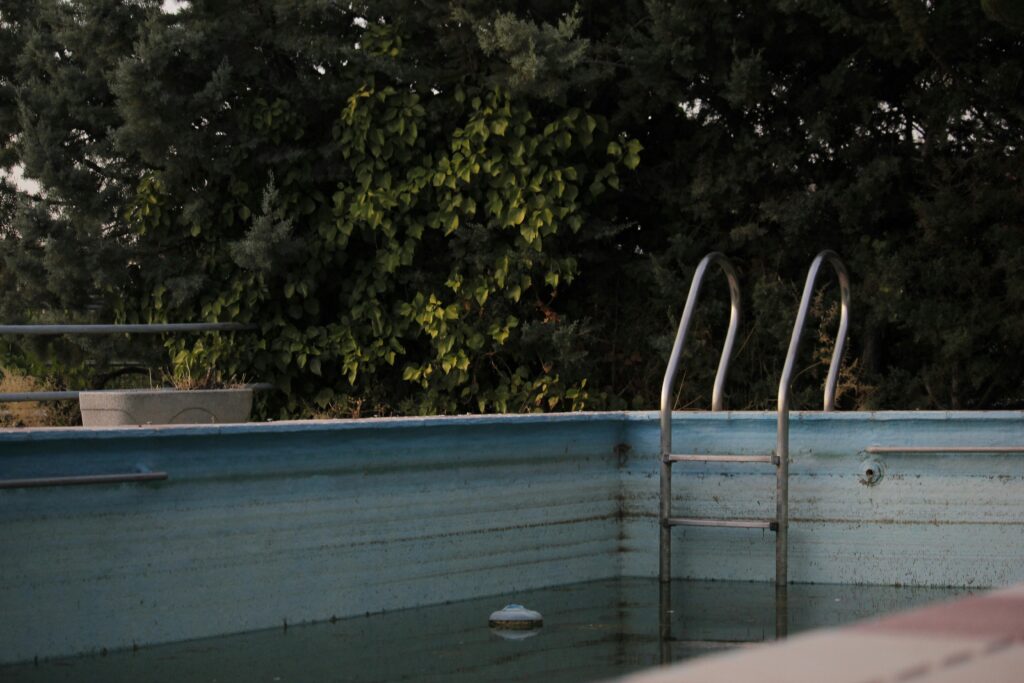 Neglected backyard swimming pool.